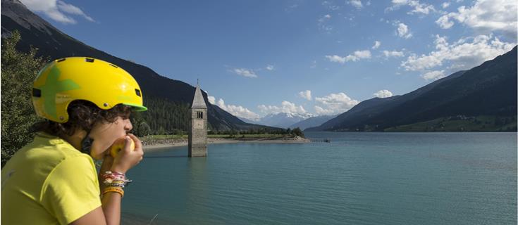 landschaft-reschensee-junge-isst-apfel-vinschgau-tg